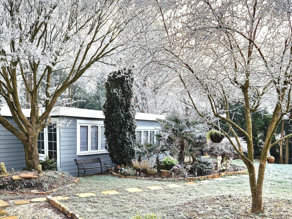 A garden with a house and trees at 1 Bed Cottage-Museum View-Garden-Free Parking, Weybridge, Surrey