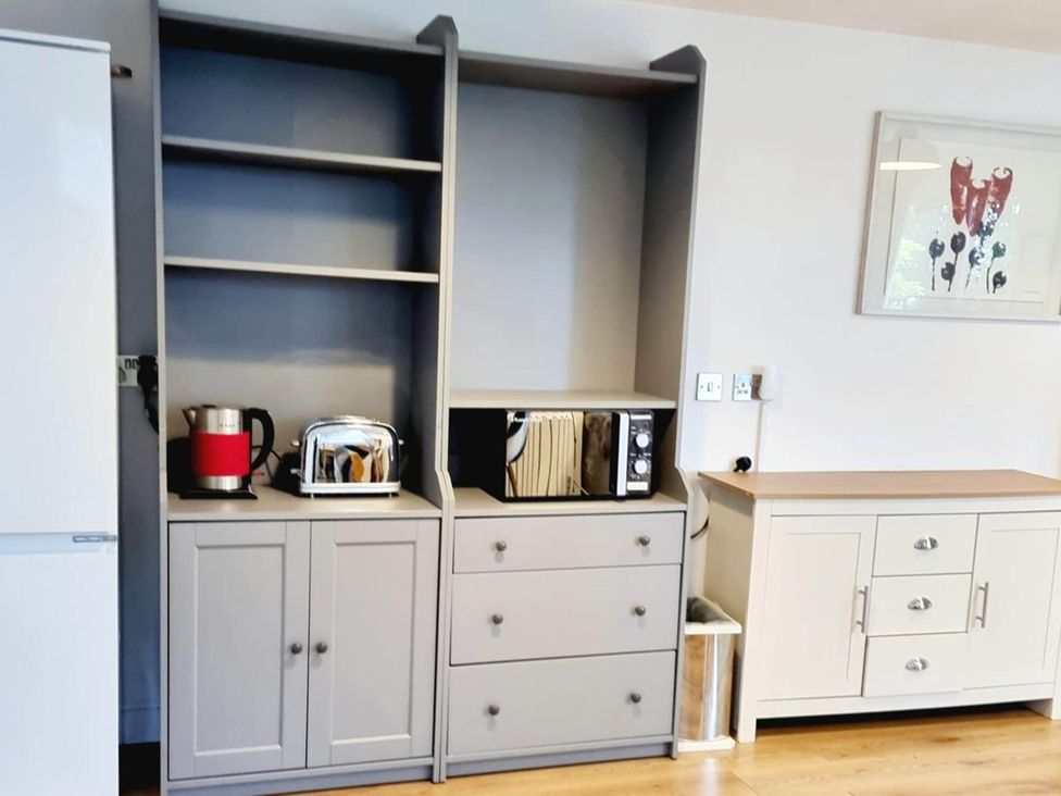 A kitchen with appliances on a cabinet at 1 Bed Cottage-Museum View-Garden-Free Parking, Weybridge, Surrey