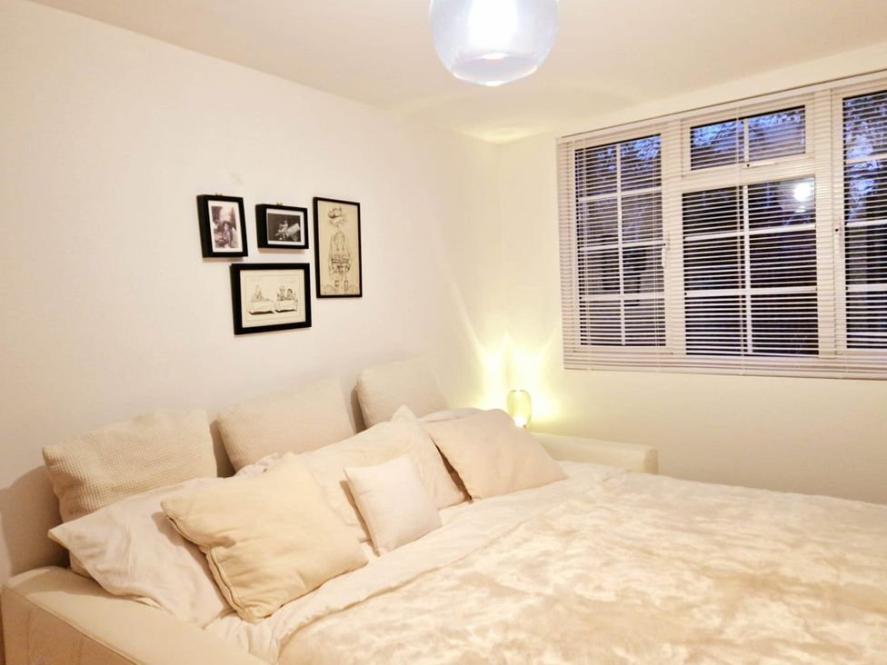 A bedroom with a bed, pillows, pictures on the wall at 1 Bed Cottage-Museum View-Garden-Free Parking, Weybridge, Surrey