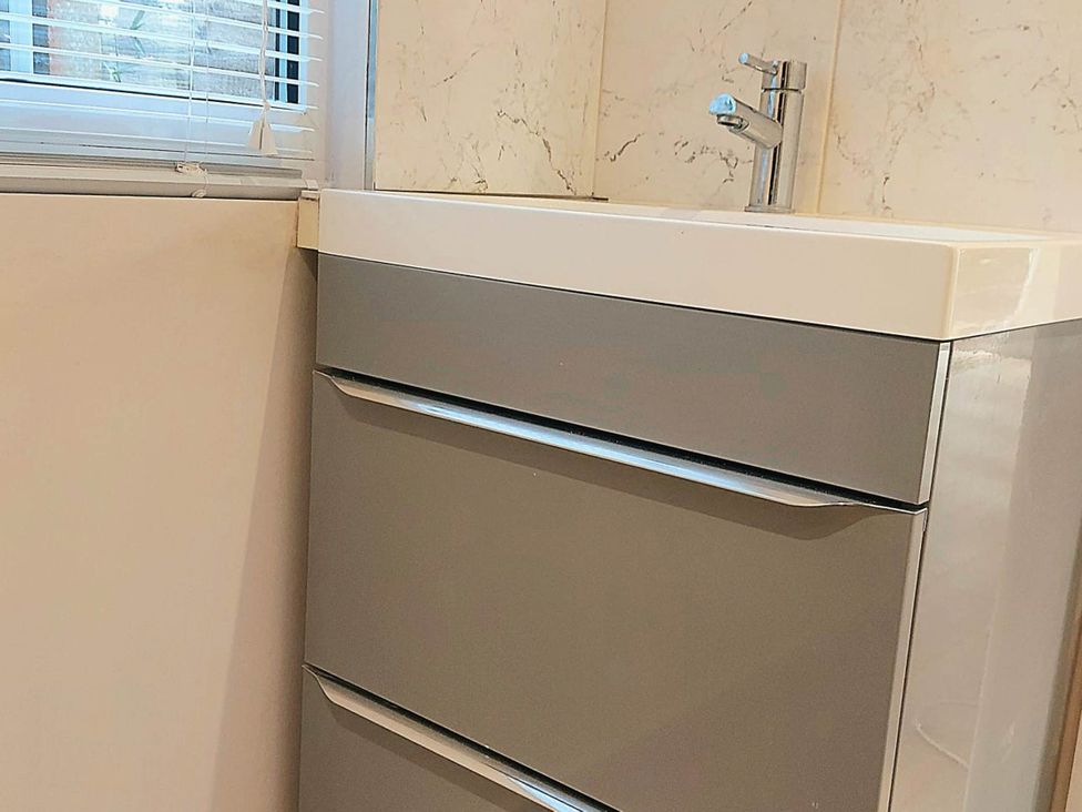 A sink with a cabinet and faucet in a bathroom at 1 Bed Cottage-Museum View-Garden-Free Parking, Weybridge, Surrey