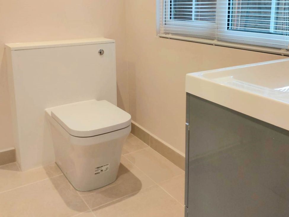 A bathroom with a toilet and sink at 1 Bed Cottage-Museum View-Garden-Free Parking in Weybridge, Surrey