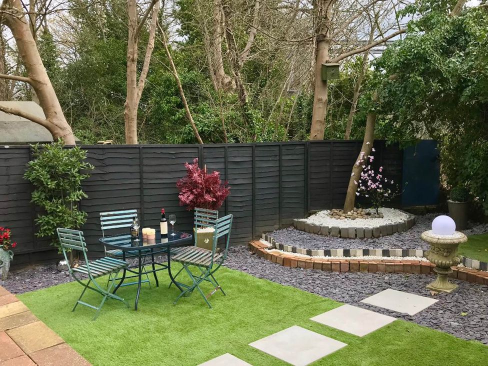 A garden with a table and chairs at 1 Bed Cottage-Museum View-Garden-Free Parking Weybridge, Surrey