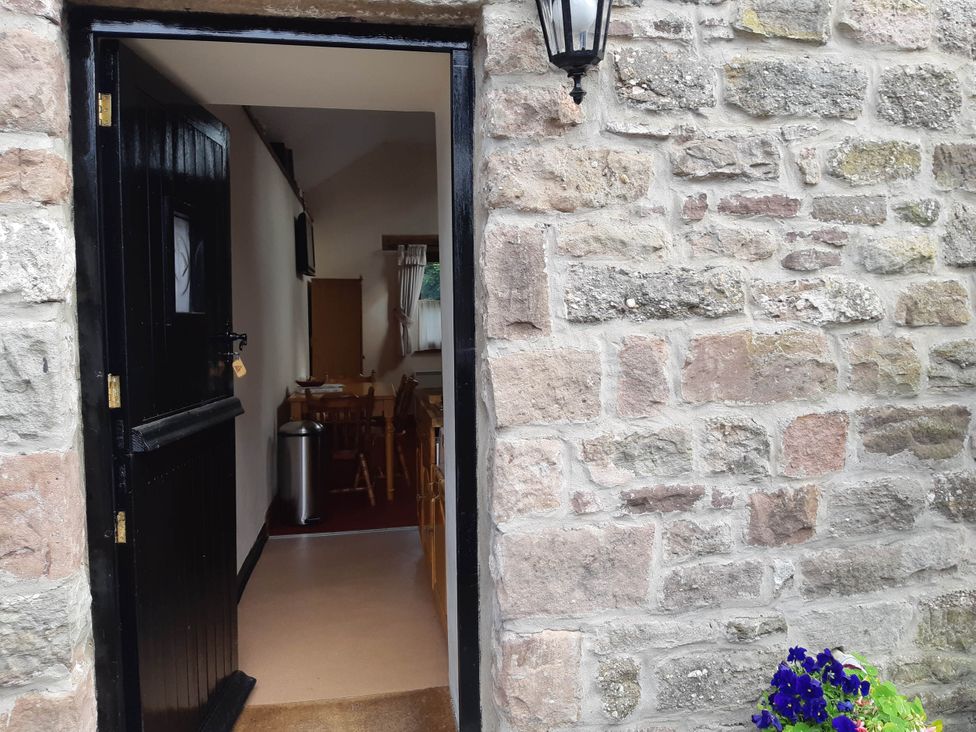 An entrance view with a door leading to a dining area at Beautiful 1-Bed Cottage in Trellech