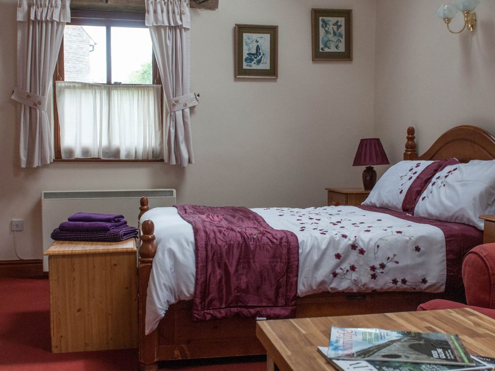 A bedroom with a bed and a window at Beautiful 1-Bed Cottage in Trellech