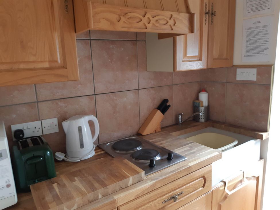 A kitchen with a cooker, kettle, and sink at Beautiful 1-Bed Cottage in Trellech