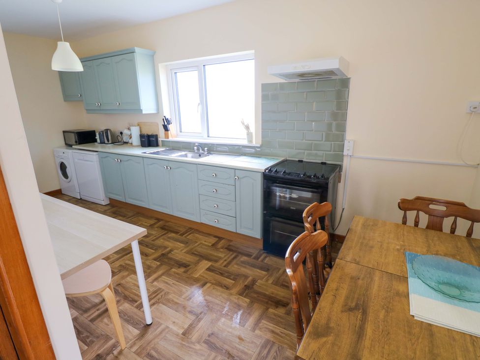 A kitchen with cabinets, stove, and table at Ocean View in Westport