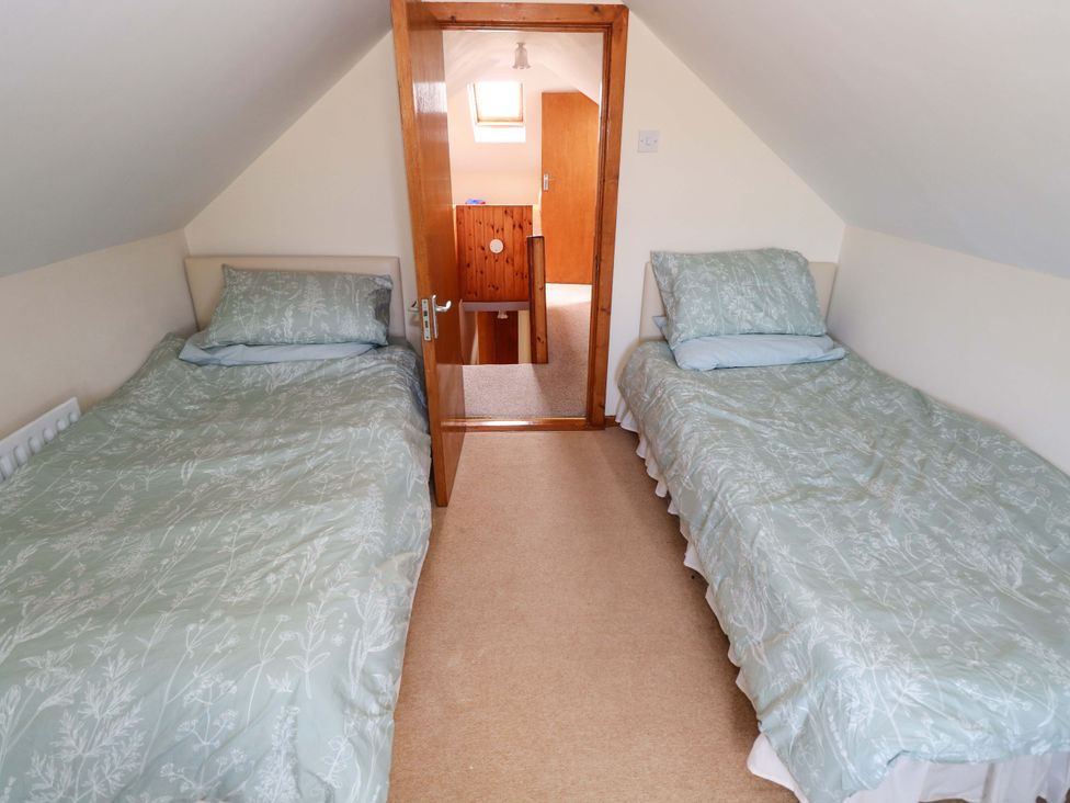 A bedroom with two beds and a door leading to another room at Ocean View in Westport