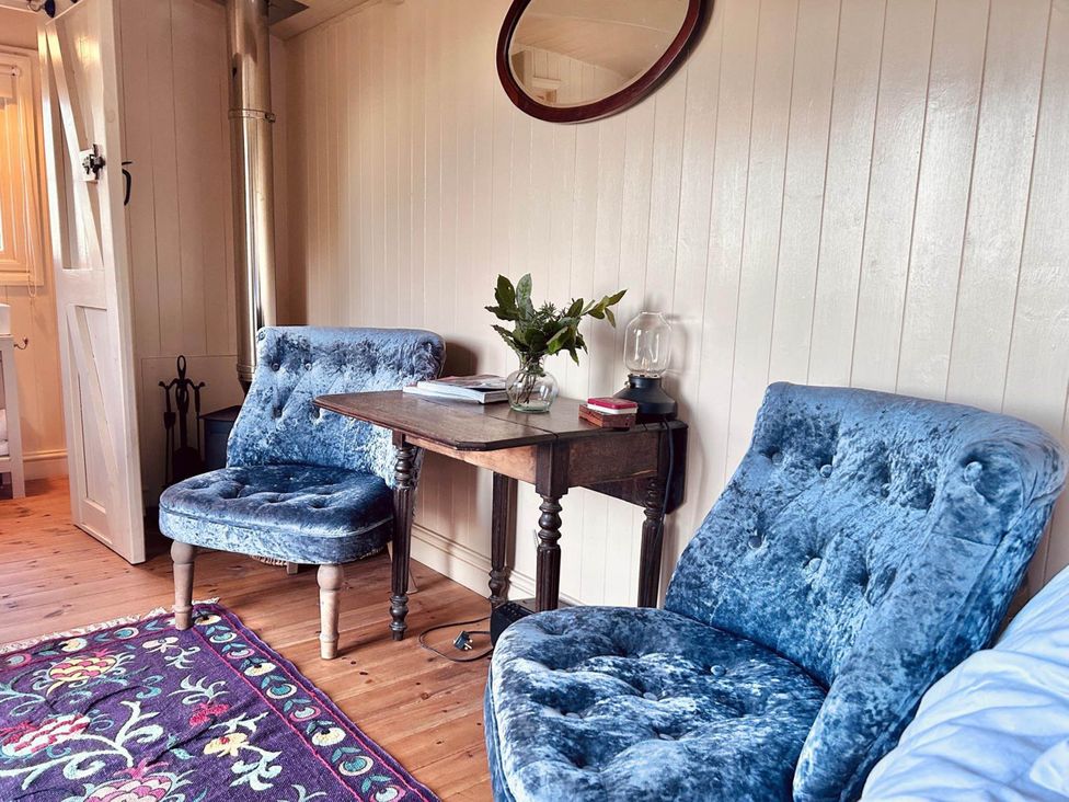 A snug with two blue chairs and a small table at Cozy Cabin Retreat near Chepstow