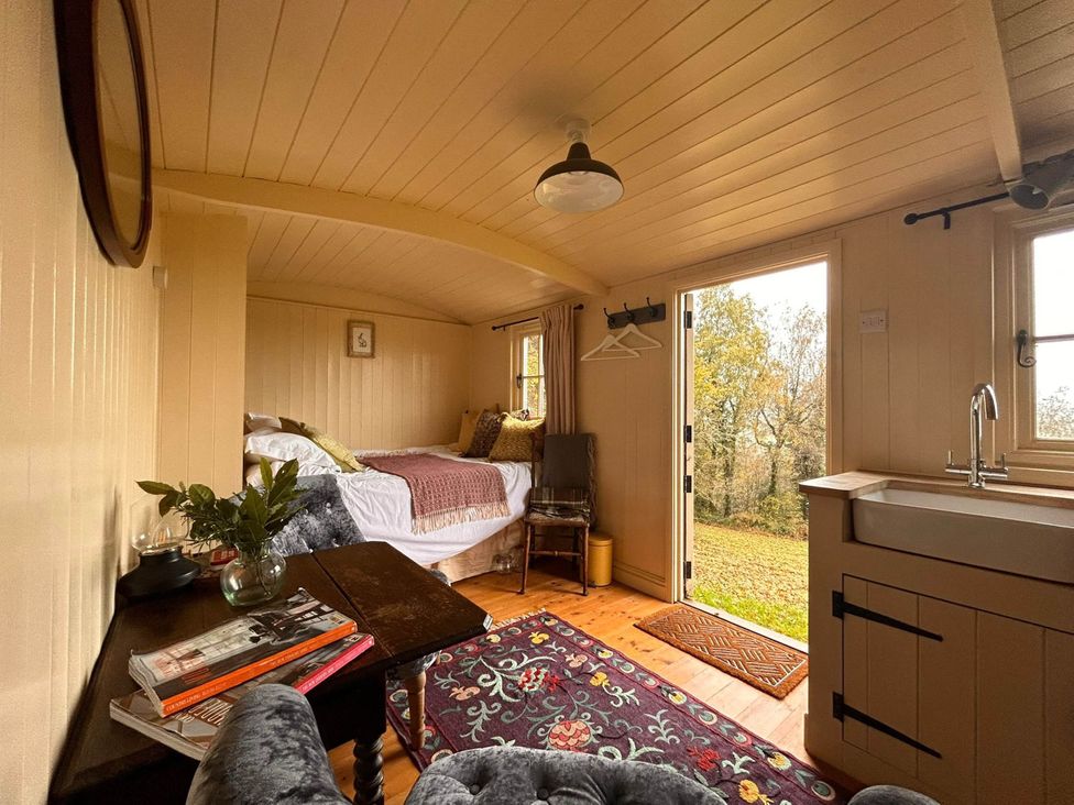 A bedroom with a bed and a sink at Cozy Cabin Retreat near Chepstow