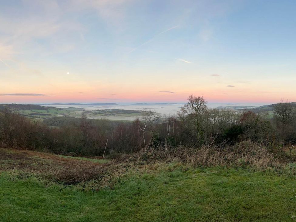 A panoramic view of rolling hills and trees at Cozy Cabin Retreat near Chepstow