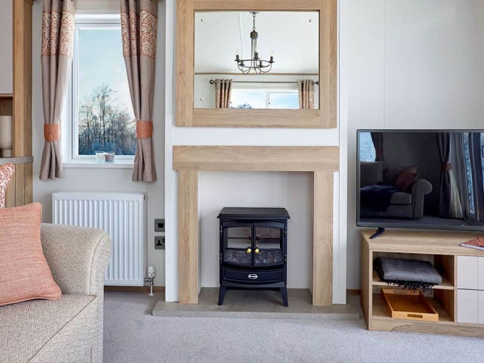 A living room with a fireplace and television at 2 Bed Lodge Sleeps 4 - Pet Welcome - Fireplace, Cirencester