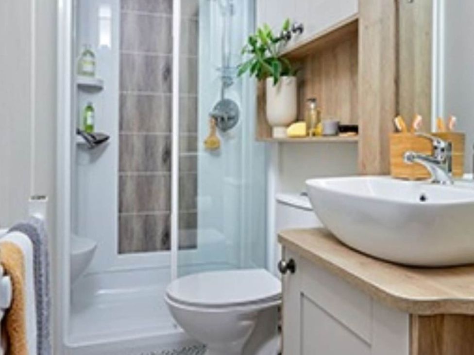 A bathroom with a shower, toilet, and sink at 2 Bed Lodge Sleeps 4 - Pet Welcome - Fireplace, Cirencester