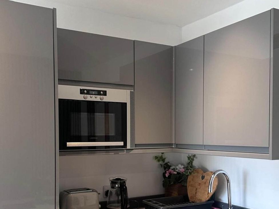 A kitchen with cabinets and a microwave at Beautiful 1-Bed studio in Penrith