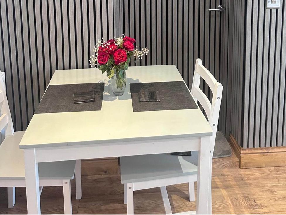 A dining room with a table and flower vase at Beautiful 1-Bed studio in Penrith