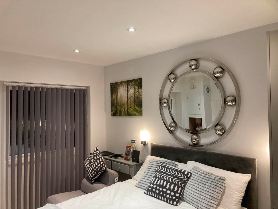 A bedroom with a bed and mirror at Beautiful 1-Bed studio in Penrith
