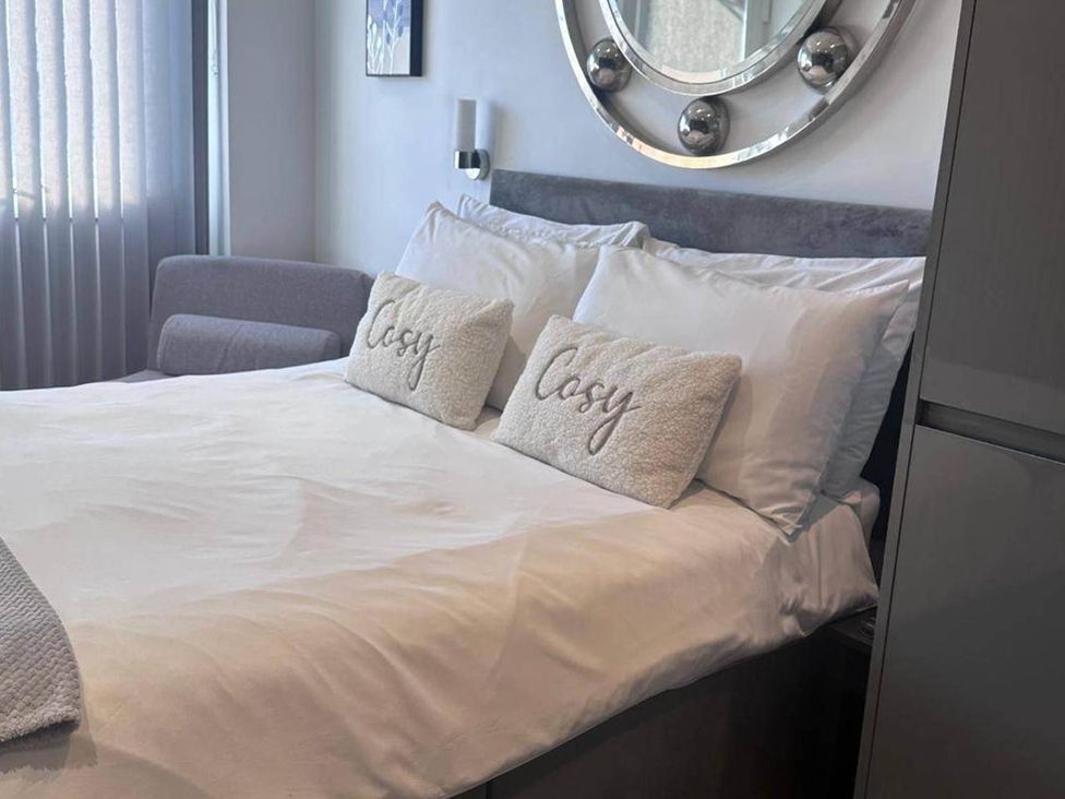 A bedroom with a bed and a sofa at Beautiful 1-Bed studio in Penrith