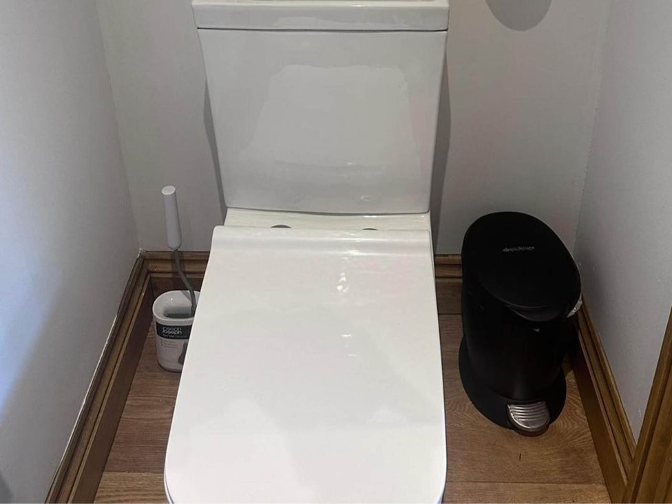 A toilet and a waste bin in a bathroom at Beautiful 1-Bed studio in Penrith