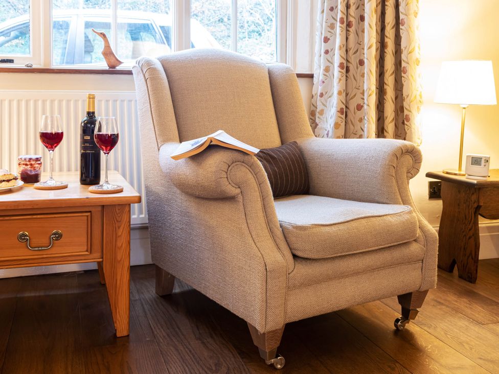 A living room with an armchair and side table with wine and cookies at Ingleton 2-Bed Cottage, Sleeps 4, Pet Ok & Parking, Ingleton