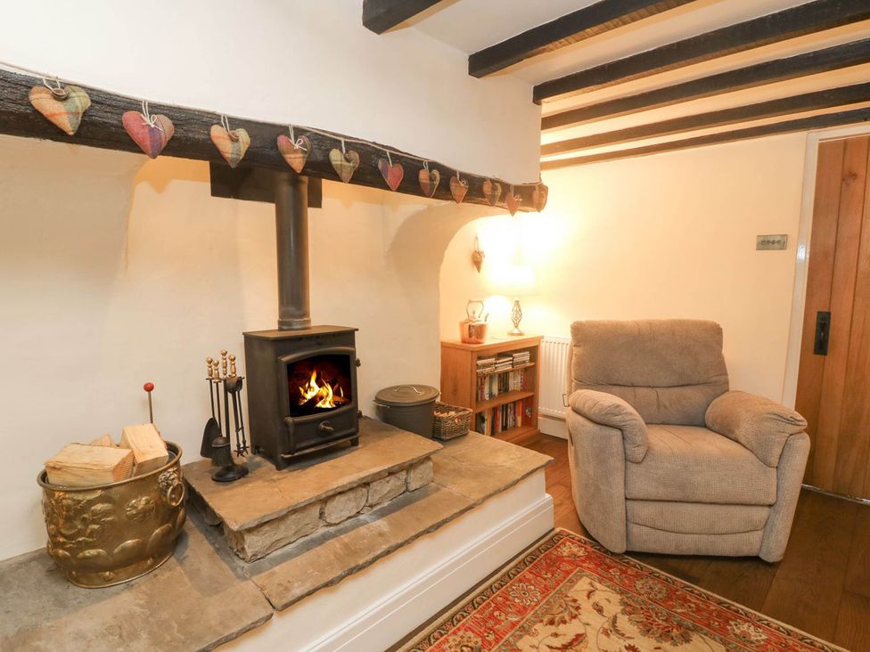 A living room with a wood stove and armchair at Ingleton 2-Bed Cottage, Sleeps 4, Pet Ok & Parking Ingleton