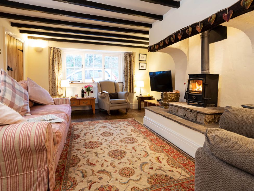 A living room with a sofa, armchair, and wood stove at Ingleton 2-Bed Cottage, Sleeps 4, Pet Ok & Parking, Ingleton