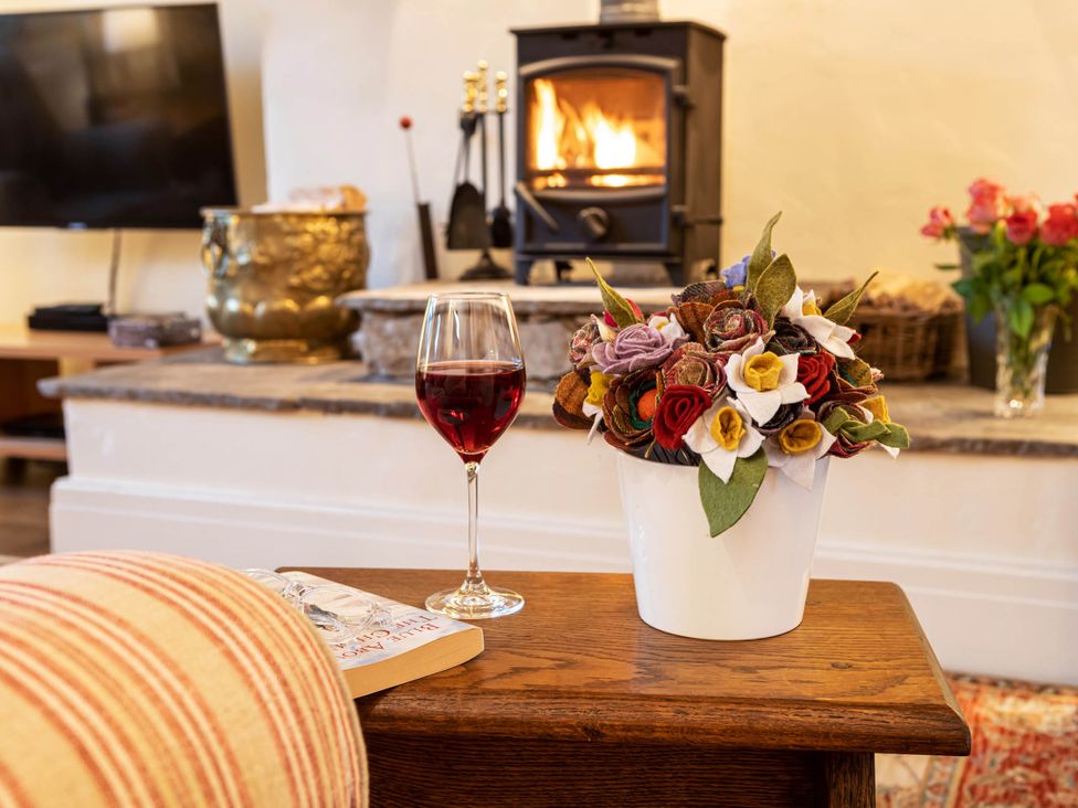 A living room with a glass of wine and flower arrangement at Ingleton 2-Bed Cottage, Sleeps 4, Pet Ok & Parking, Ingleton