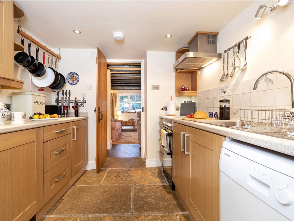 A kitchen with countertop, sink, oven, and door at Ingleton 2-Bed Cottage, Sleeps 4, Pet Ok & Parking Ingleton