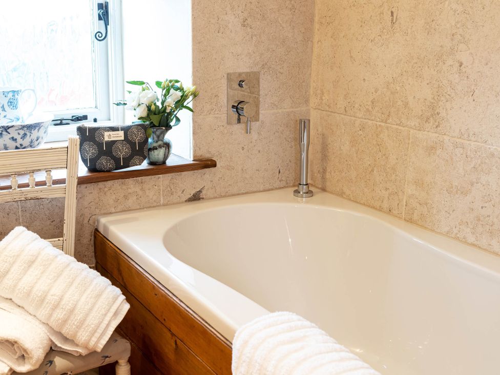 A bathroom with a bathtub and towels at Ingleton 2-Bed Cottage, Sleeps 4, Pet Ok & Parking, Ingleton