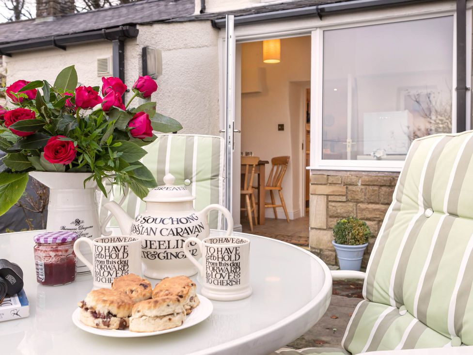 A dining room with flowers and scones on the table at Ingleton 2-Bed Cottage, Sleeps 4, Pet Ok & Parking, Ingleton