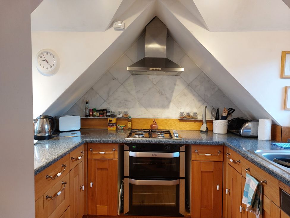 A kitchen with wooden cabinets and cooking appliances at 1 Bed Lodge - Sleeps 2 - Parking - Wifi in Salen