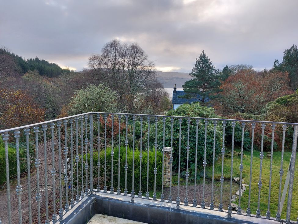 A balcony view overlooking trees and water at 1 Bed Lodge - Sleeps 2 - Parking - Wifi, Salen