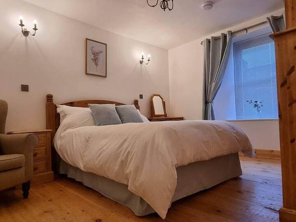 A bedroom with a bed, nightstand and chair at The Coal Office, Aberlour