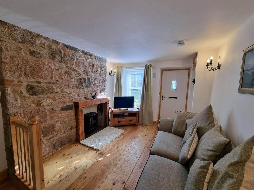 A living room with a sofa and television at The Coal Office, Aberlour