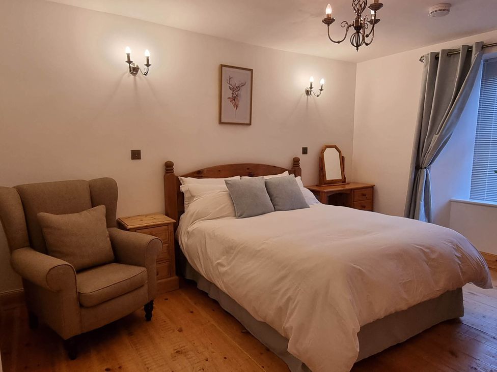 A bedroom with a bed and armchair at The Coal Office, Aberlour