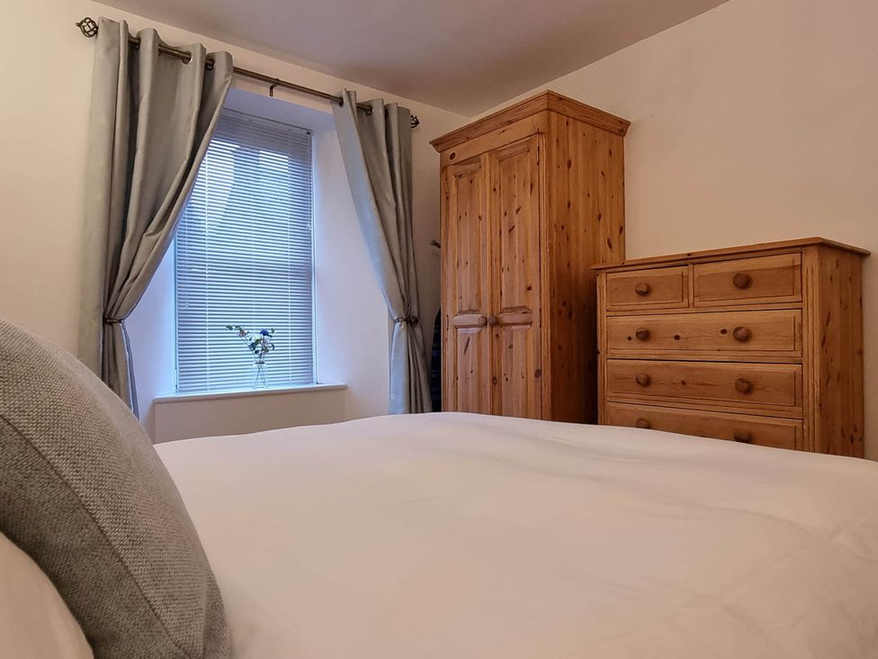 A bedroom with a bed, wardrobe, and dresser at The Coal Office, Aberlour