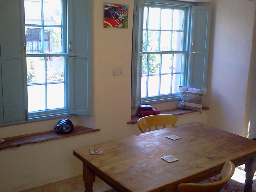 A dining room with windows and a wooden table at Cottage - Sleeps 4 - Pets Ok - Garden - Parking Carnforth