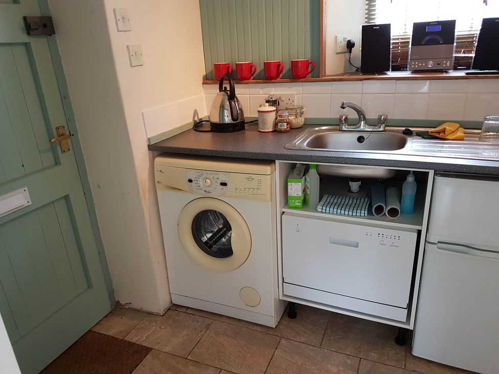 A kitchen with a washing machine, sink and kettle at Cottage - Sleeps 4 - Pets Ok - Garden - Parking in Carnforth