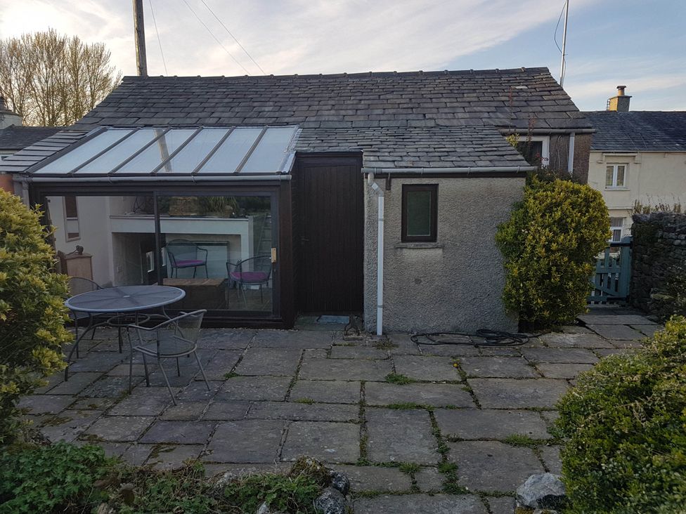 An outdoor view of a conservatory with a table and chairs at Cottage - Sleeps 4 - Pets Ok - Garden - Parking in Carnforth