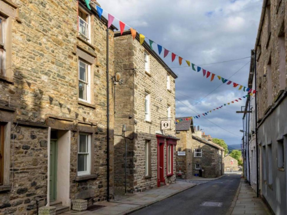 A street with stone buildings and pennant flags at Sedbergh Penthouse - KingBed - Tv - Wifi, Sedbergh