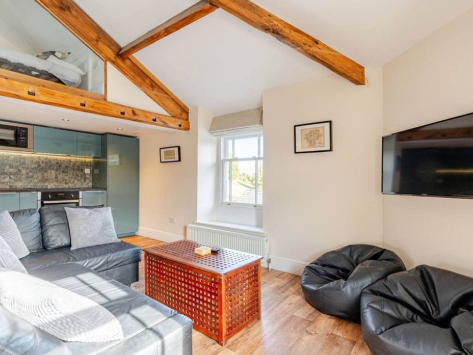 A living room with a sofa, coffee table, and television at Sedbergh Penthouse - KingBed - Tv - Wifi in Sedbergh