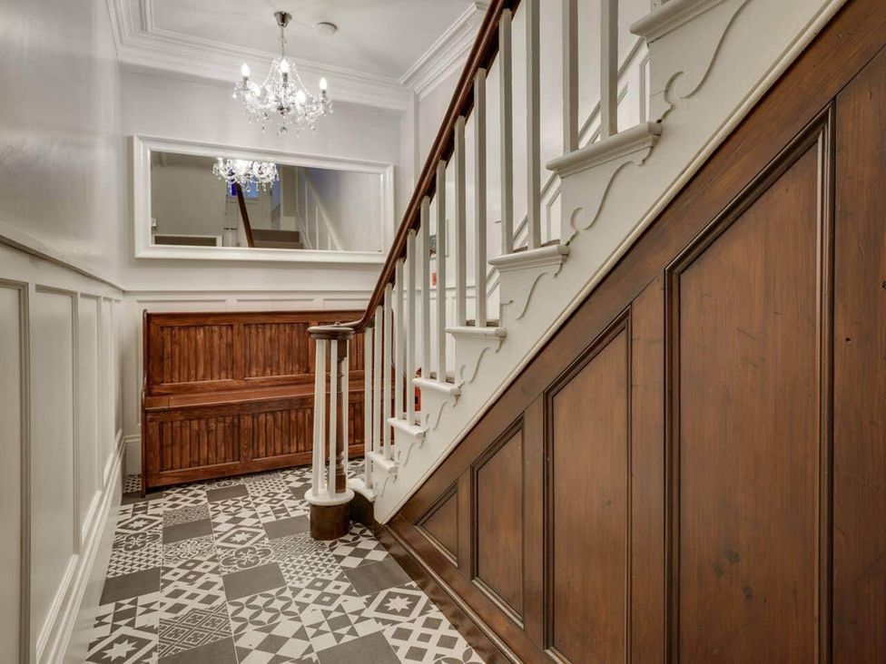 A hallway with a staircase and a wooden bench at Sedbergh Penthouse - KingBed - Tv - Wifi Sedbergh