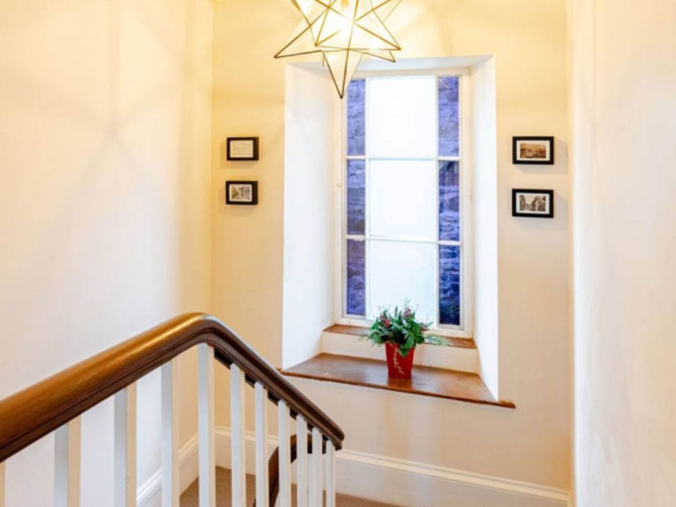 A staircase with a window and pictures on the wall at Sedbergh Penthouse - KingBed - Tv - Wifi Sedbergh