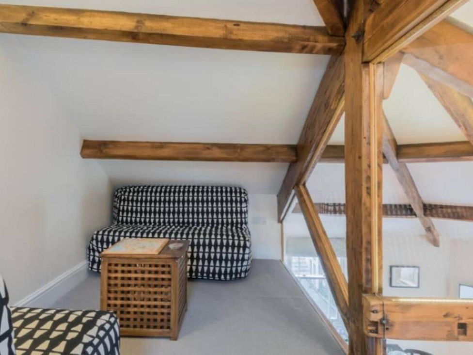 A loft area with a sofa and coffee table at Sedbergh Penthouse - KingBed - Tv - Wifi Sedbergh