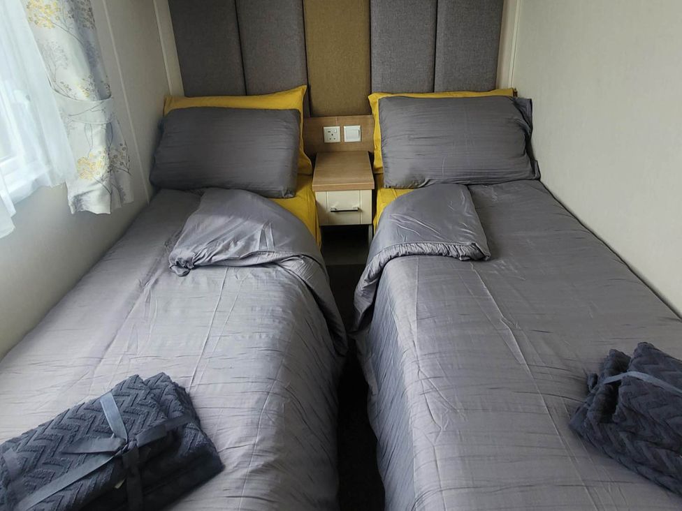 A bedroom with two beds and a bedside table at Beachside Lodge - Sleeps 6 - Pets ok - Parking Heysham