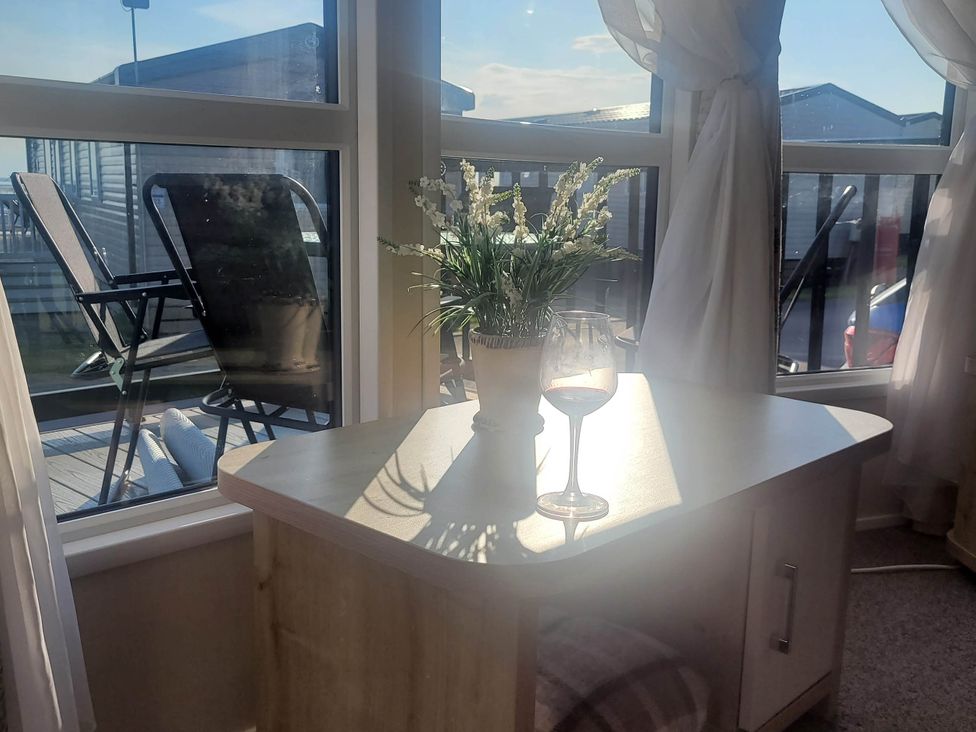 A snug area with a table and glass at Beachside Lodge - Sleeps 6 - Pets ok - Parking in Heysham