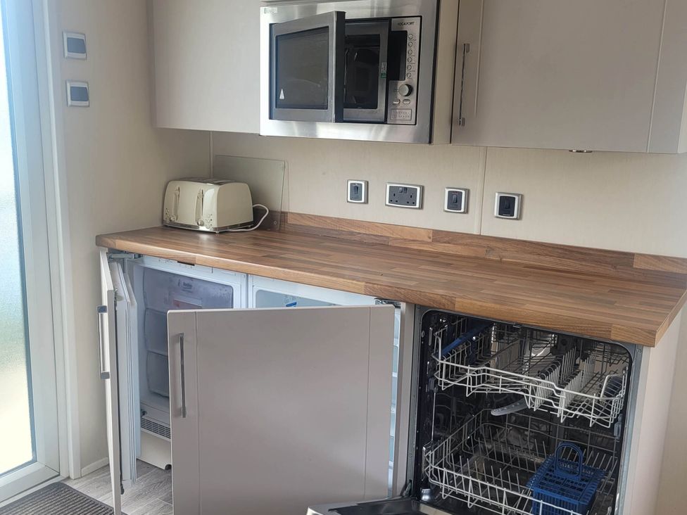 A kitchen with a fridge, dishwasher, microwave, and toaster at Beachside Lodge - Sleeps 6 - Pets ok - Parking in Heysham