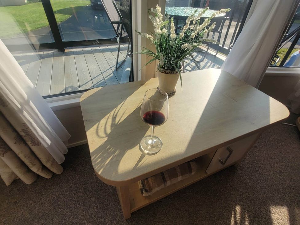 A living room with a table, wine glass, and artificial plant at Beachside Lodge - Sleeps 6 - Pets ok - Parking in Heysham