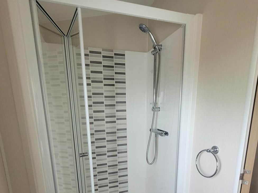 A shower with glass door and wall tiles at Beachside Lodge - Sleeps 6 - Pets ok - Parking Heysham