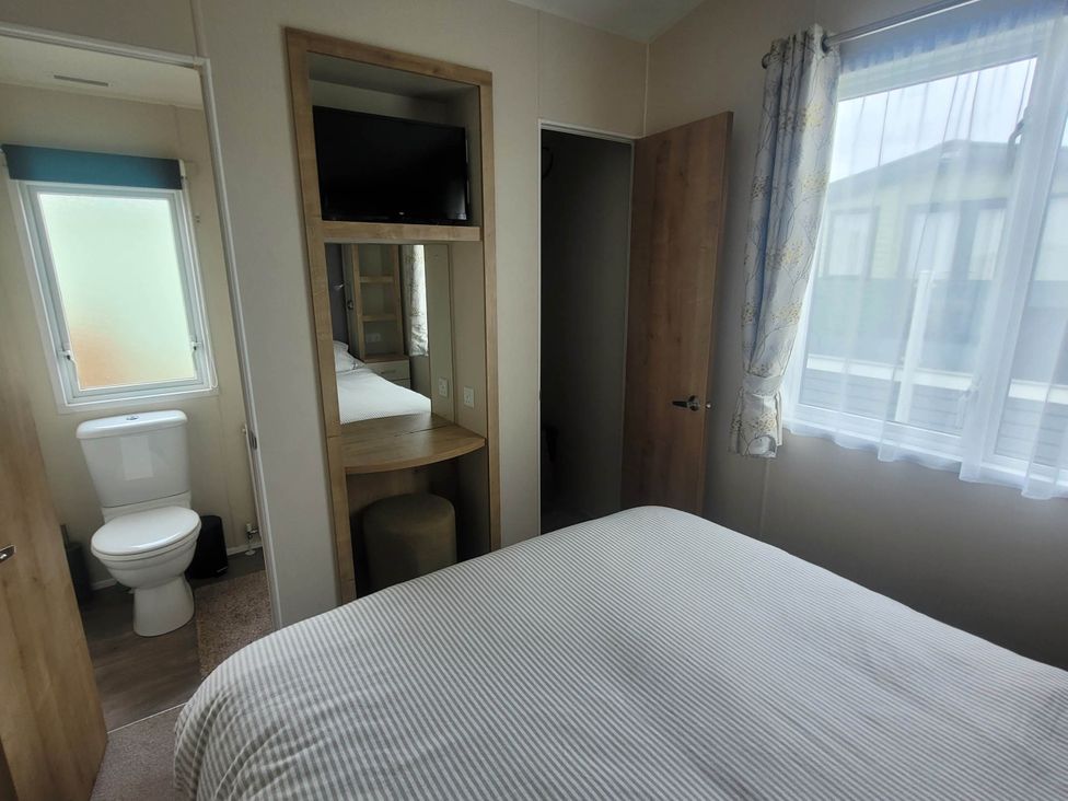 A bedroom with a bed and a toilet in the corner at Beachside Lodge - Sleeps 6 - Pets ok - Parking Heysham