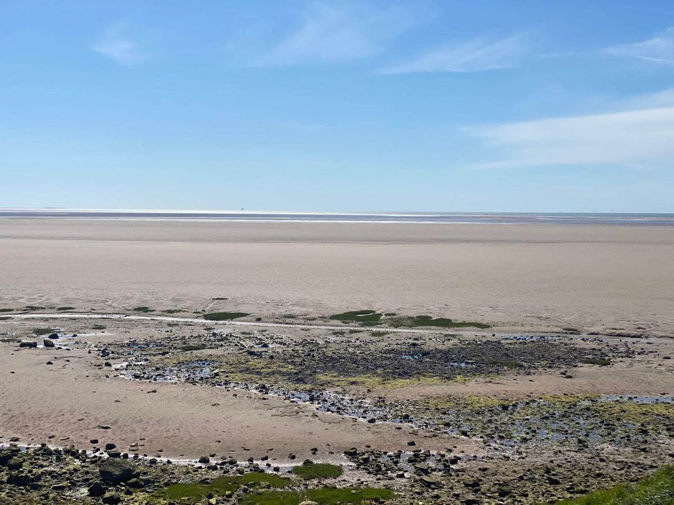 A beach with rocks and tidal water at Beachside Lodge - Sleeps 6 - Pets ok - Parking in Heysham