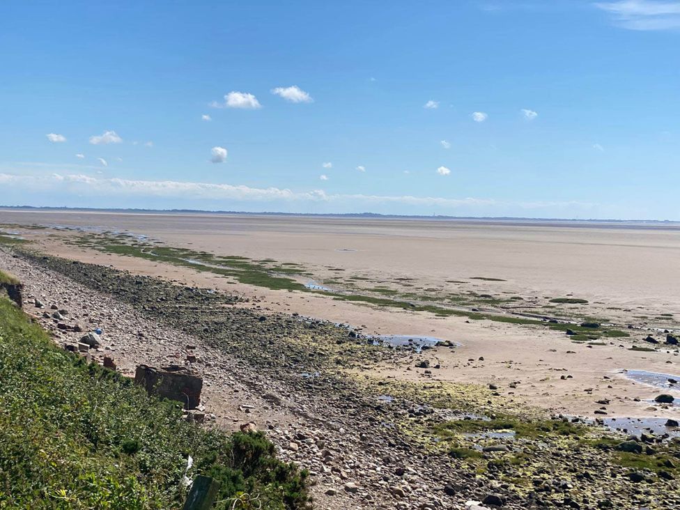A beach view with rocks and water at Beachside Lodge - Sleeps 6 - Pets ok - Parking Heysham